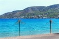 Two old straw umbrellas on the beach. Nice view of Salamis island in Greece.