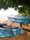 Two old traditional wooden boats or canoe for fishing waiting on the beach for the rain to stop