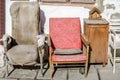 Two old vintage retro broken reclining seats porvanoy cloth on a background of white whitewashed wall with cracks and old bedside