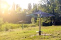 Two Old vintage wooden beach umbrellas on an abandoned, grassy and reed river beach on a sunny summer day