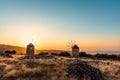 Two old windmills in the middle of the mountains, sunset time. Royalty Free Stock Photo