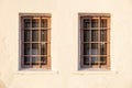 Two old windows and banister metal railing on white wall background. House security, front view