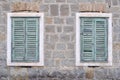 Two old windows with closed shutters on an old house Royalty Free Stock Photo