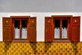 Two old windows with opened shutters on white wall and yellow ti Royalty Free Stock Photo