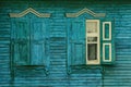 Two old windows with wooden shutters on the green wall of a rural house Royalty Free Stock Photo