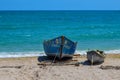 Two old wooden row-boats of different sizes on the sandy beach of the Black Sea on a clear, blue sky, sunny summer day