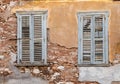 Two old wooden windows on grunge weathered wall.