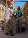 Two old worker shifts block of stone