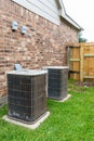 Two older air conditioner systems next to brick home with copy space Royalty Free Stock Photo