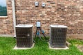 Older HVAC air conditioner units next to brick home with copy space Royalty Free Stock Photo