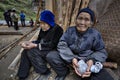 Two older farmer Asians, rural women, sitting near peasant house