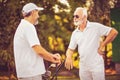 Older men stand on a golf course and talk Royalty Free Stock Photo