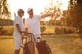 Older men stand on a golf course and talk Royalty Free Stock Photo