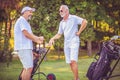 Older men stand on a golf course and talk Royalty Free Stock Photo