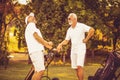 Older men stand on a golf course and talk Royalty Free Stock Photo