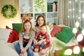 Two older sisters and their cute little baby brother having fun together in a cozy living room on Christmas eve. Kids spending Royalty Free Stock Photo