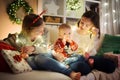 Two older sisters and their cute little baby brother having fun together in a cozy living room on Christmas eve. Kids spending Royalty Free Stock Photo