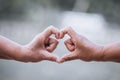 Two older women making heart shape with hands together