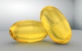 Two omega capsules, top view.Omega 3 acid, yellow gelatin capsule 3d rendering illustration. Vitamin drop gold pill