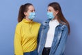 Two omen wearing disposable protective face mask and casual outfits. Coronavirus, covid 19, virus epidemic concept, girls friends Royalty Free Stock Photo