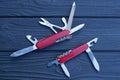 two open folding knives multitools with red handles with gray blades