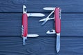 two open folding knives multitools with red handles with gray blades Royalty Free Stock Photo