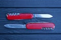 two open folding knives with red handles with gray blades Royalty Free Stock Photo