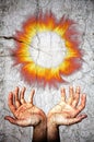 Two opened hands upwards and fire flames crown. Crack marble surface. Royalty Free Stock Photo