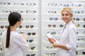Two ophthalmologists wearing white coats standing in optical store