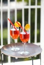 Two orange cocktails with straw on wooden table