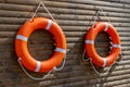 Two orange lifebuoys hanging on a wall