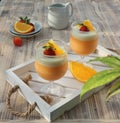 two orange puddings in glasses garnished with sliced ??oranges and strawberries Royalty Free Stock Photo