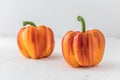 Two orange and red "enjoya" bell peppers (capsicum) on white background Royalty Free Stock Photo