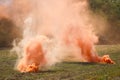 Two orange smoke grenades on the battlefield