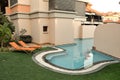 Two orange sun loungers stand by empty pool in evening after sunset in hotel resort Dubai UAE