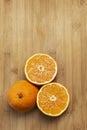 Two oranges, one cut in half and one whole on a bamboo board Royalty Free Stock Photo