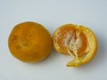 two oranges, one peeled on a white background Royalty Free Stock Photo
