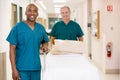 Two Orderlies Pushing Bed Down A Hospital Corridor Royalty Free Stock Photo