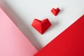 Two origami hearts on white background and pink and red paper borders; above. Creative postcard for Valentine`s day Royalty Free Stock Photo