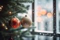 two ornaments hanging from a christmas tree in front of a window Royalty Free Stock Photo