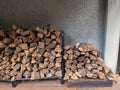 Two outdoor firewood piles in overcast outdoor building