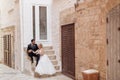 Two overdressed people, groom and bride, woman and man, just married. Hugging, sitting together, look each other, church