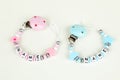 Two pacifier chains in blue and pink Royalty Free Stock Photo