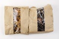 Packs of dog treats on a white background. Brown paper bags with