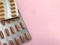 Two packs of pills lie on a bright pink background. preparations of red and brown color on the corner Royalty Free Stock Photo