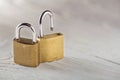 Two padlock, lock and unlock, with silvered keys on white wooden background. Estate and security concept with symbol of protection Royalty Free Stock Photo