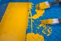 Two paint brushes on a blue plastic tray with yellow paint
