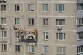 Repair of the facade of the building by workers at a height Royalty Free Stock Photo