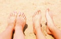 Two pair of bare feen on the sunny sand beach Royalty Free Stock Photo
