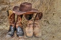 Two pair of cowboy boots and a hat on hay Royalty Free Stock Photo